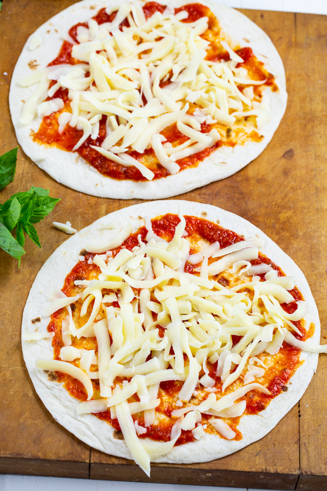 Cheese sprinkled over pizza sauce.