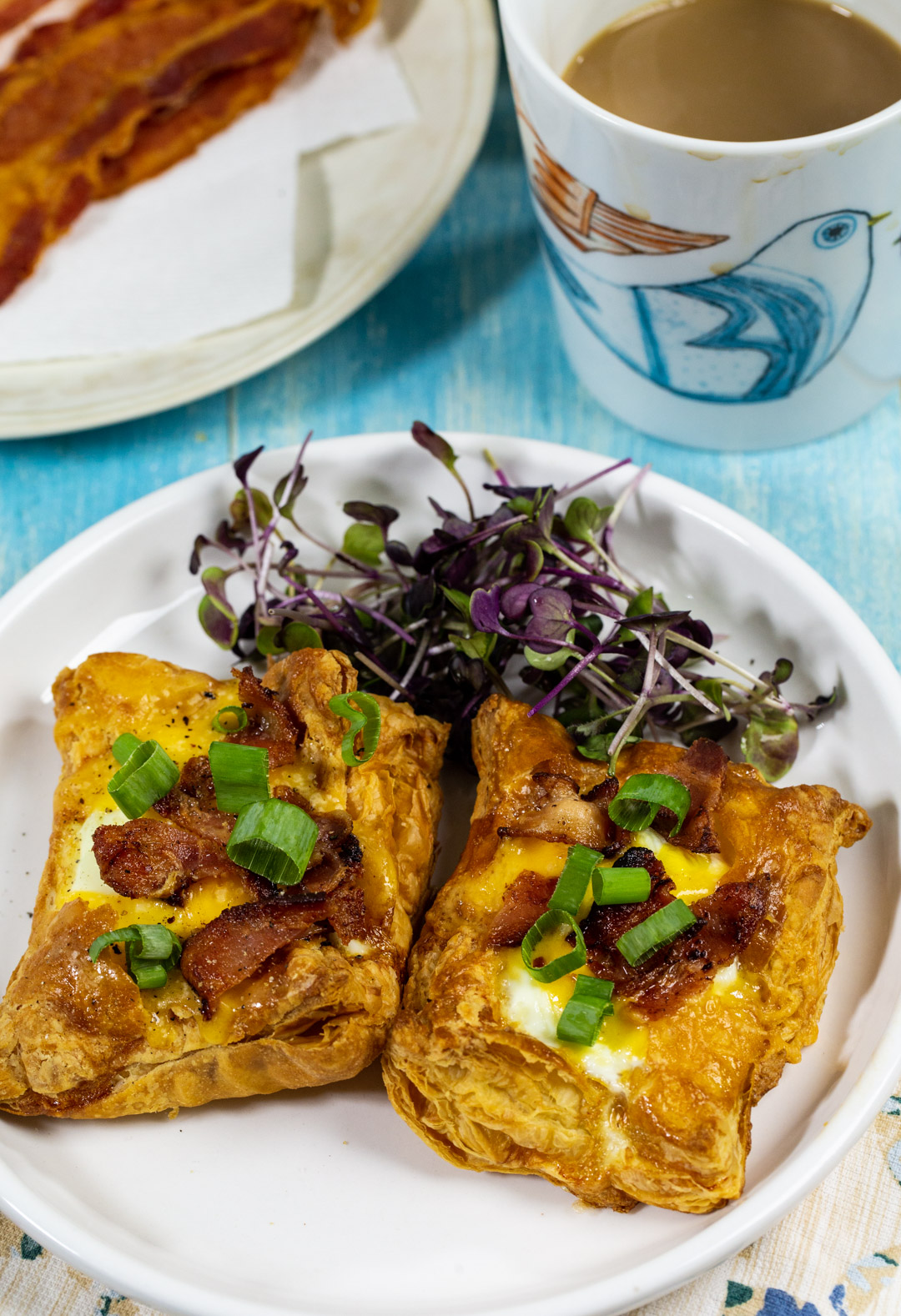 Two puff pastry pieces on plate with greens.