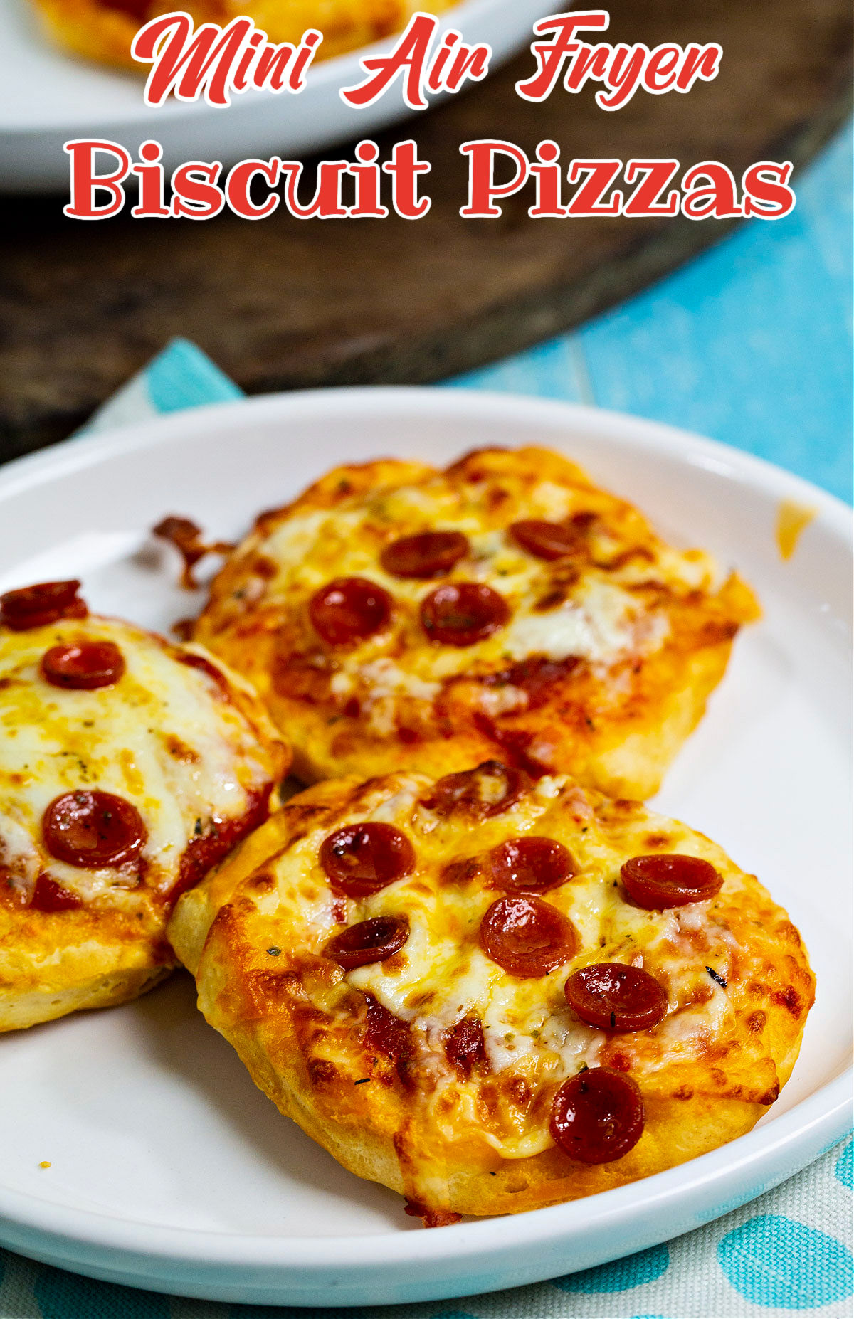 Mini pizzas topped with mini pepperoni on a plate.