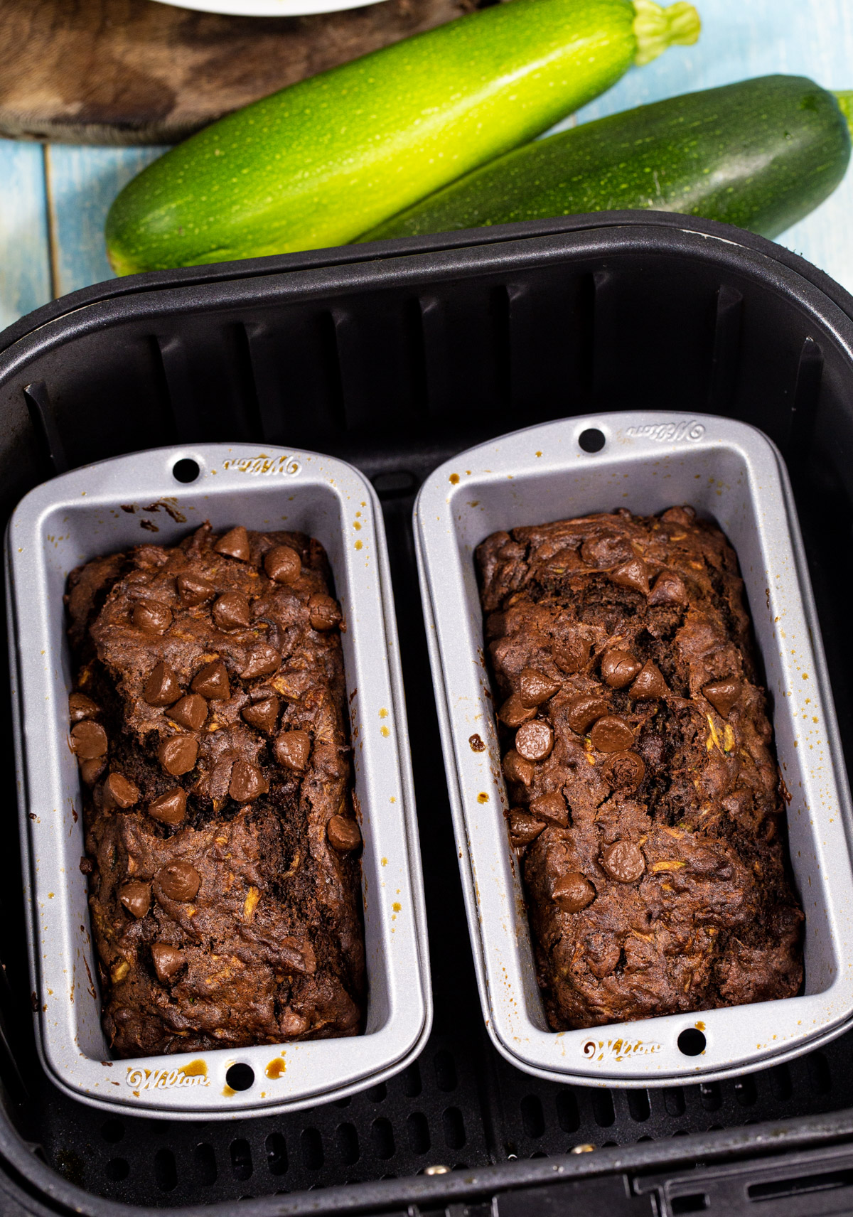 Two mini loaves of bread in air fryer basket.