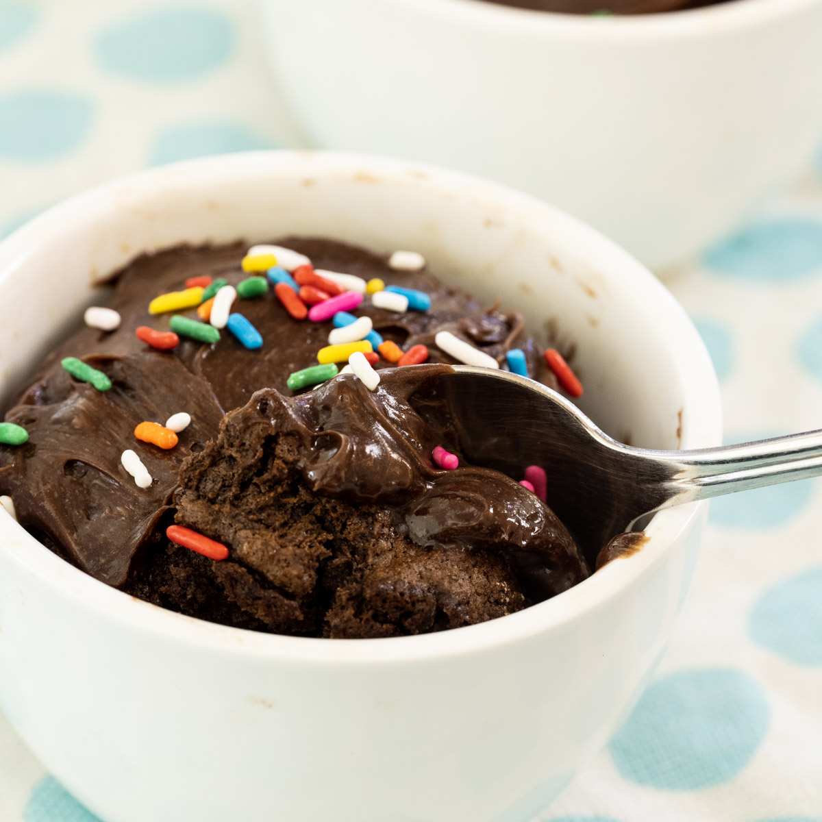 Spoon scooping into Air Fryer Chocolate Mug Cake.