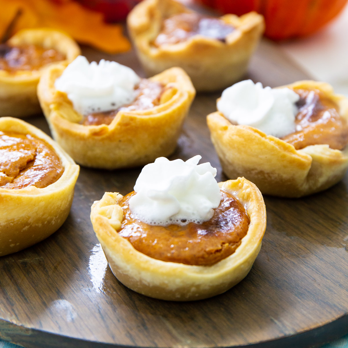 Air Fryer Mini Pumpkin Tarts on a wooden board.