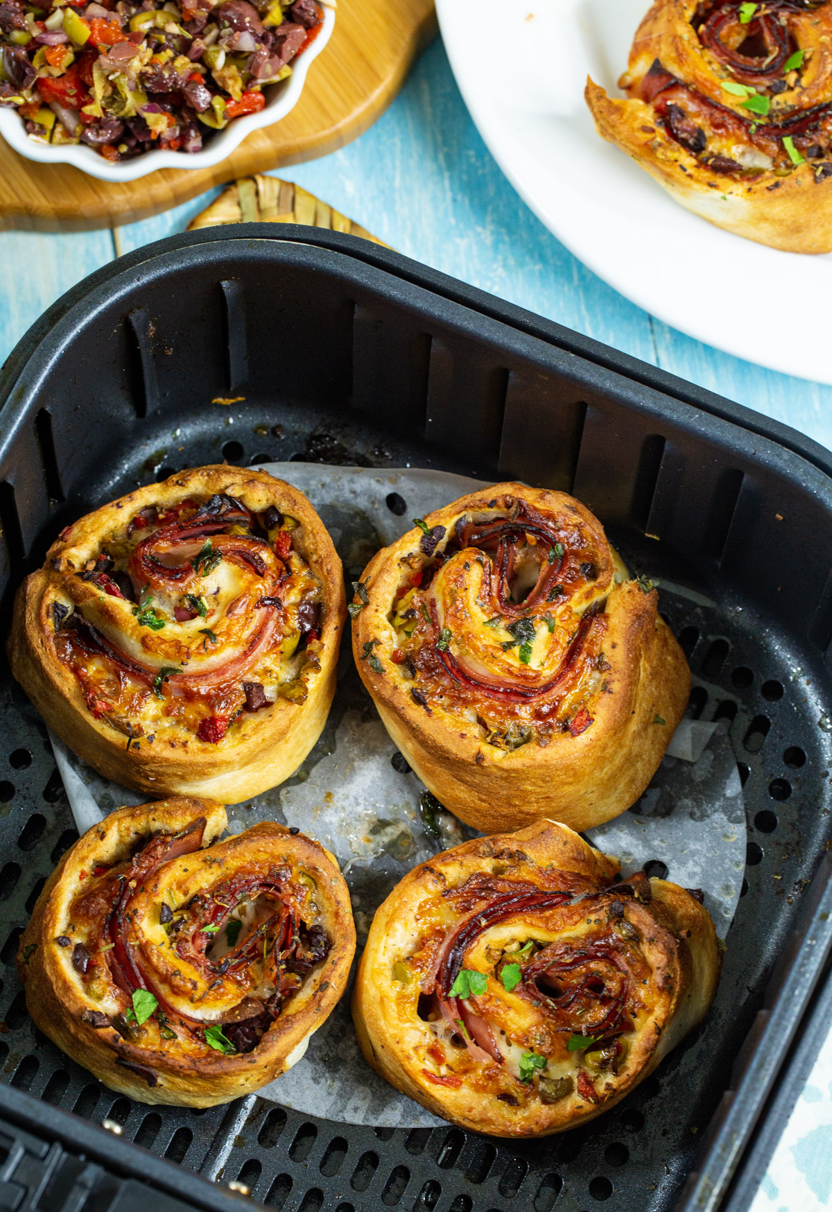 Pizza rolls in air fryer basket.