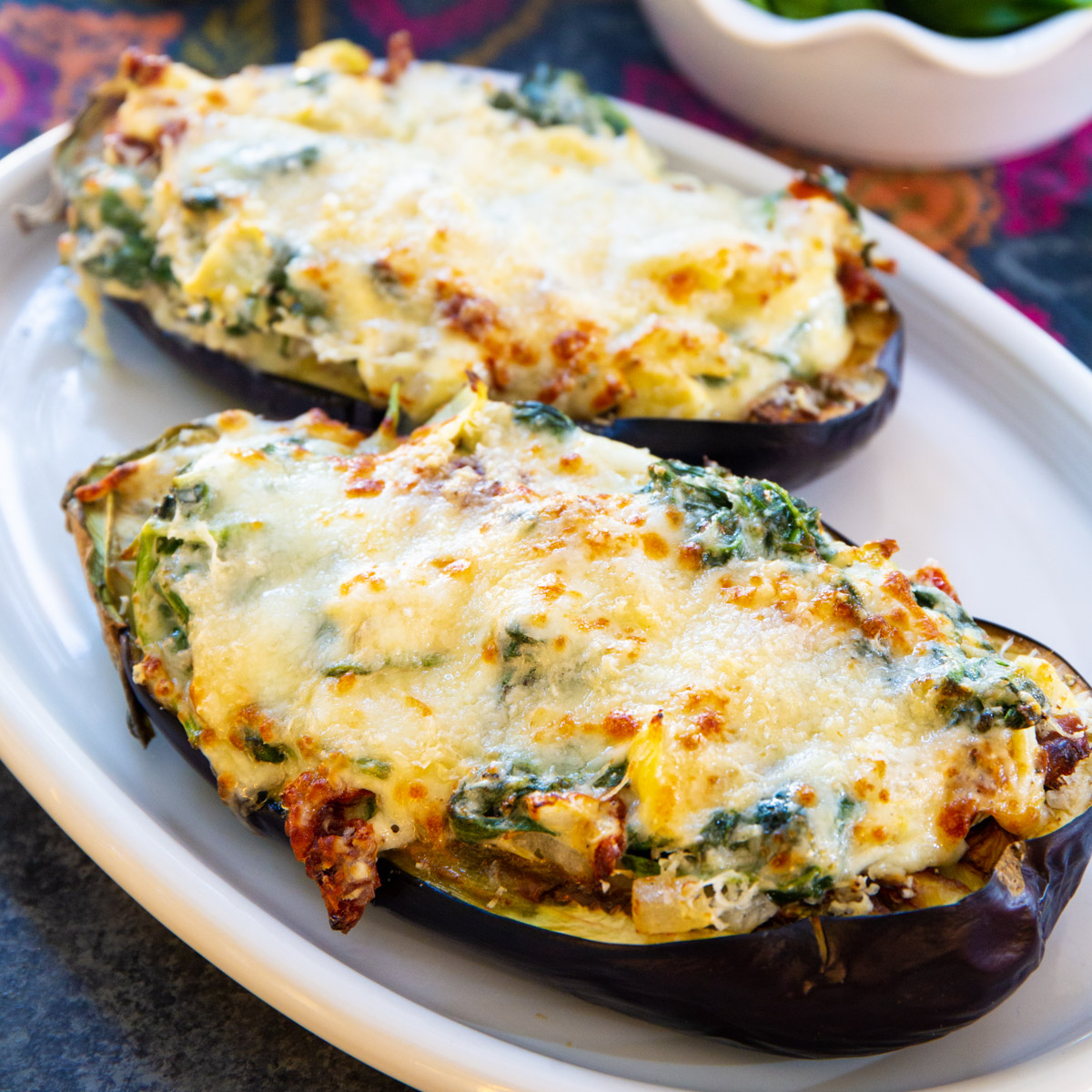 Two eggplant halves stuffed with spinach artichoke mixture.