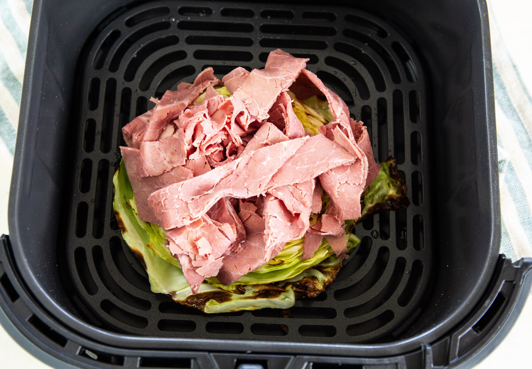 Corned beef added to cabbage steak.