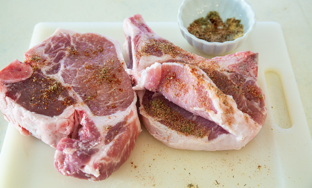 Pork chops seasoned and slit cut in middle.