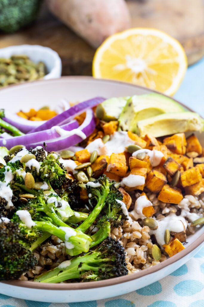 Farro bowls with broccoli and sweet potatoes in a wide serving bowl.