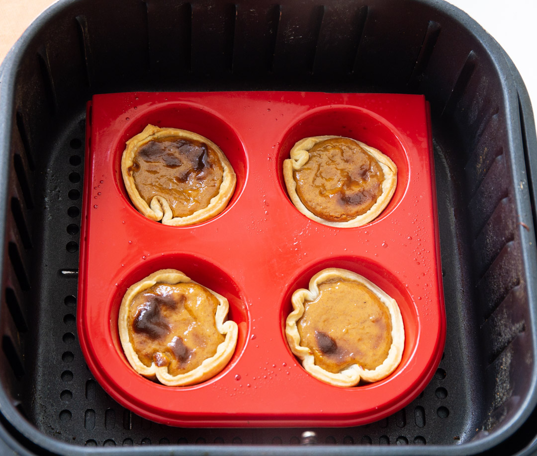 Four tarts in the air fryer basket.